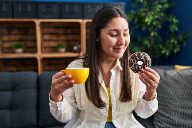 Genç İspanyol kadın evde kahvaltı ederken kendine güler yüzlü.