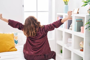 Genç, güzel İspanyol bir kadın yatak odasında kollarını açarak uyanıyor.