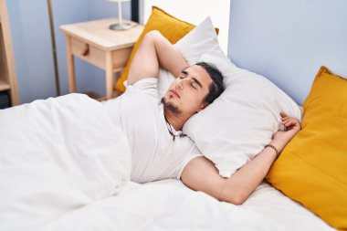 Young man sleeping on bed at bedroom
