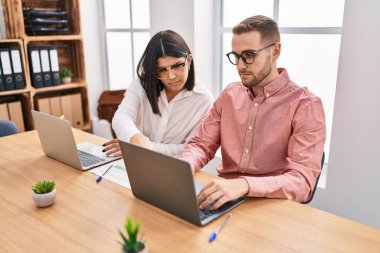 Kadın ve erkek işçiler ofiste çalışıyor.