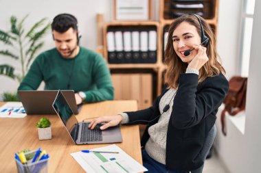 Man and woman call center agent using laptop working at office
