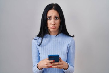 Akıllı telefon kullanan İspanyol kadın üzgün ve endişeli, sinirli ve korkmuş. hüzünlü ifade. 