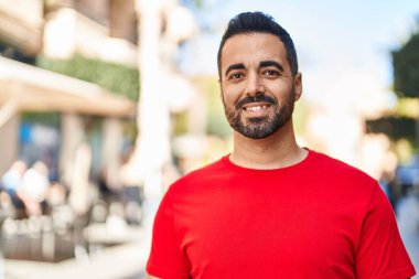 Sokakta kendinden emin gülümseyen İspanyol genç adam.