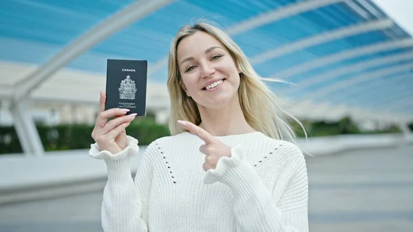 Joven Mujer Rubia Sonriendo Confiado Señalando Canadá Pasaporte Parque —  Fotos de Stock