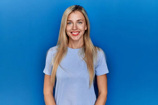Piękna Blondynka Luźnej Koszulce Niebieskim Tle Szczęśliwym Chłodnym Uśmiechem Twarzy — Zdjęcie stockowe