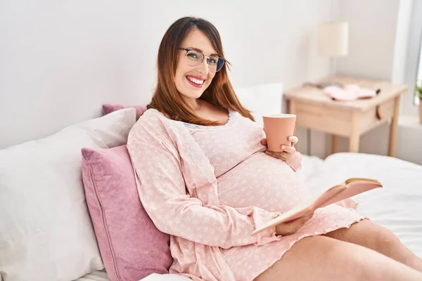 Jonge Zwangere Vrouw Drinken Kopje Koffie Lezen Boek Slaapkamer — Stockfoto