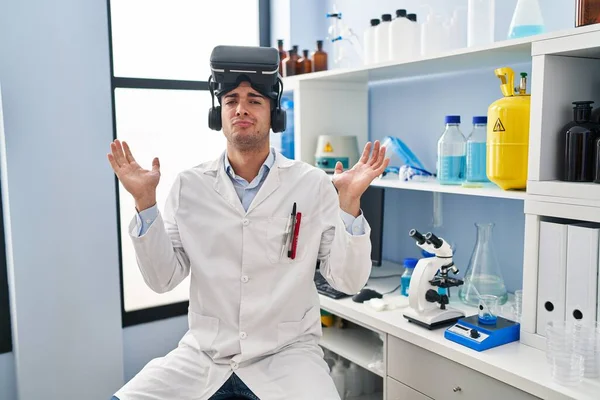 科学者研究室で働く若いヒスパニック系の男性は 口の中で手で大声で叫んで大声で叫ぶVrの眼鏡をかけています コミュニケーションの概念 — ストック写真