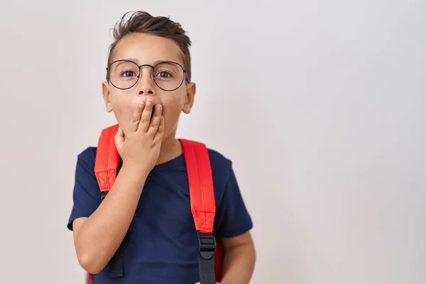 小さなヒスパニック系の少年が眼鏡をかけ 学生のバックパックを手で口をカバーし ショックを受け ミスを恐れている 驚きの表情 — ストック写真