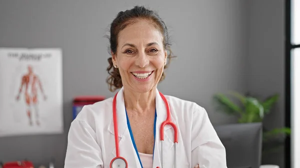 Klinikte Kendine Gülen Orta Yaşlı Spanyol Kadın Doktor — Stok fotoğraf