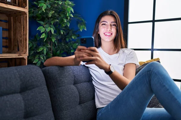 Mujer Hispana Hermosa Joven Usando Teléfono Inteligente Sentado Sofá Casa — Foto de Stock