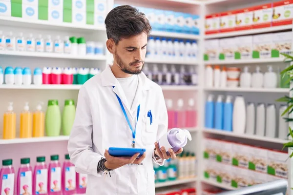 Joven Farmacéutico Hispano Usando Touchpad Sosteniendo Botella Gel Farmacia —  Fotos de Stock