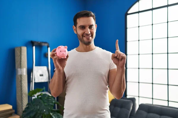 Young Hispanic Man Beard Holding Piggy Bank New Home Smiling — Stock Photo, Image