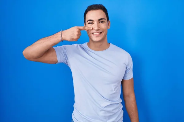 Young Hispanic Man Standing Blue Background Pointing Hand Finger Face — Foto de Stock