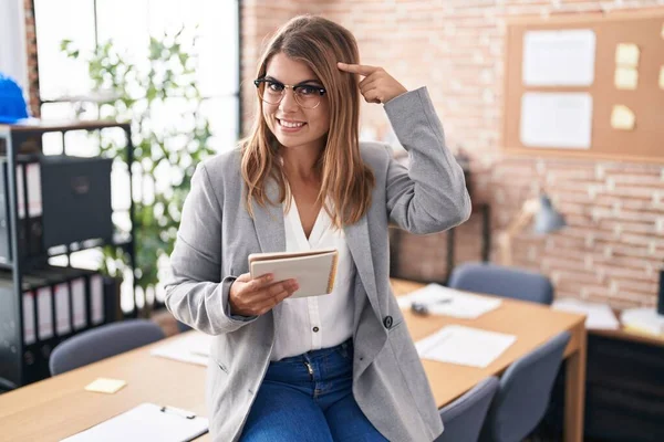 Young Hispanic Woman Working Office Wearing Glasses Smiling Pointing Head — 图库照片