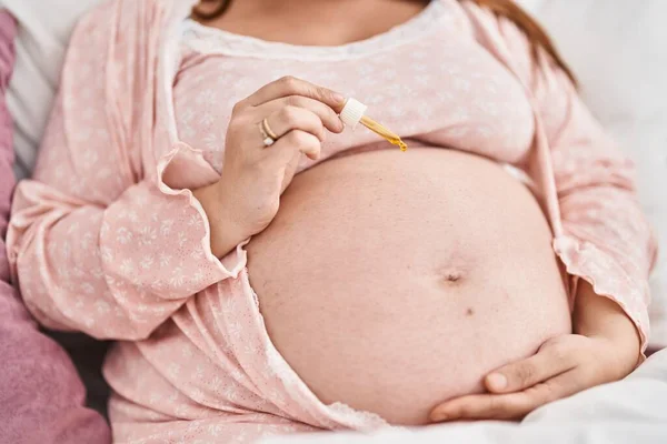 Jonge Zwangere Vrouw Die Serum Toepast Buik Slaapkamer — Stockfoto