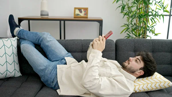 Junger Hispanischer Mann Mit Smartphone Hause Auf Sofa Liegend — Stockfoto