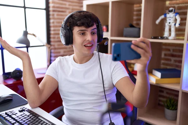 Молодой Двоичный Человек Играет Видеоигры Смартфоном Празднуя Достижение Счастливой Улыбкой — стоковое фото