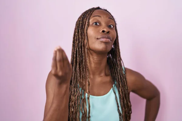 非洲裔美国妇女站在粉红的背景上 手指手画脚地做着意大利式的手势 — 图库照片