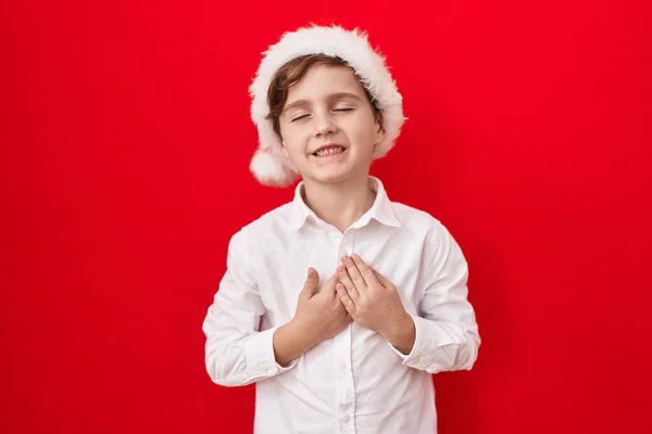Little Caucasian Boy Wearing Christmas Hat Red Background Smiling Hands — Stock Photo, Image