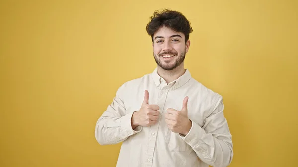 Молодой Латиноамериканец Улыбается Большими Пальцами Изолированном Желтом Фоне — стоковое фото
