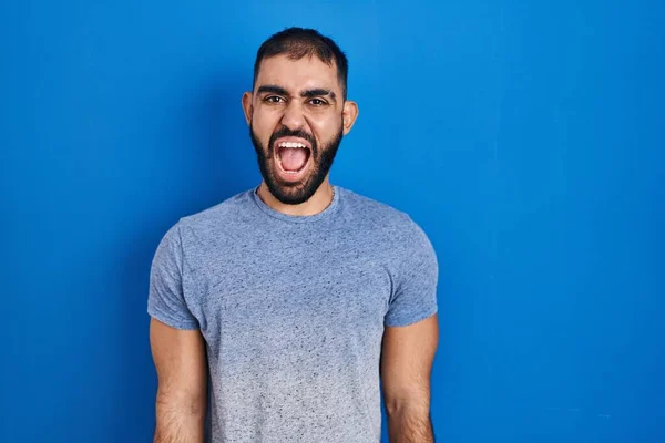 髭を生やした中東の男は 怒りと怒りで叫んで 青の背景の怒りと怒りの上に立っている 怒りと攻撃的な考え方 — ストック写真
