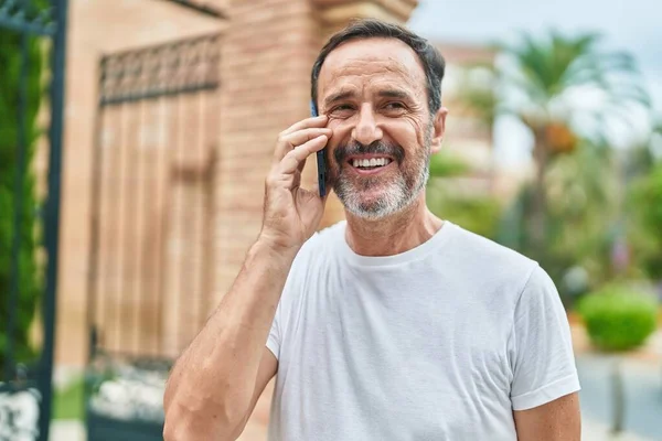 Hombre Mediana Edad Sonriendo Confiado Hablando Teléfono Inteligente Calle —  Fotos de Stock