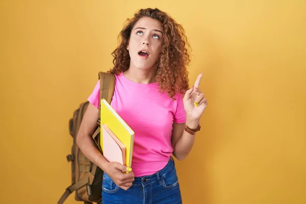 Young Caucasian Woman Wearing Student Backpack Holding Books Amazed Surprised — Stock Photo, Image