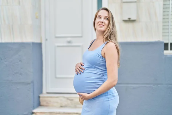 Junge Schwangere Frau Lächelt Selbstbewusst Und Berührt Bauch Auf Straße — Stockfoto