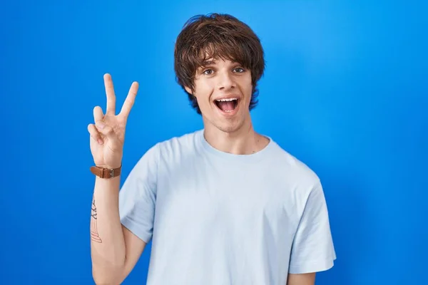 Іспанський Молодий Чоловік Стоїть Над Синім Фоном Показує Пальцем Номер — стокове фото