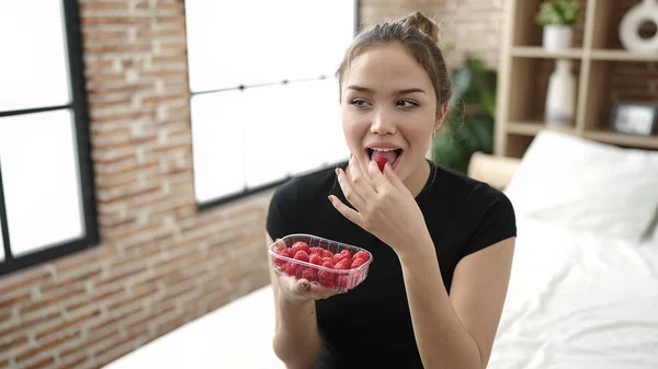 Young Beautiful Hispanic Woman Eating Raspberries Sitting Bed Bedroom — Fotografia de Stock
