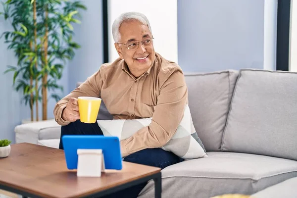 Starší Muž Pije Kávu Sledování Touchpad Doma — Stock fotografie