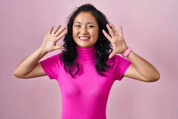Jonge Aziatische Vrouw Staande Roze Achtergrond Tonen Wijzen Met Vingers — Stockfoto