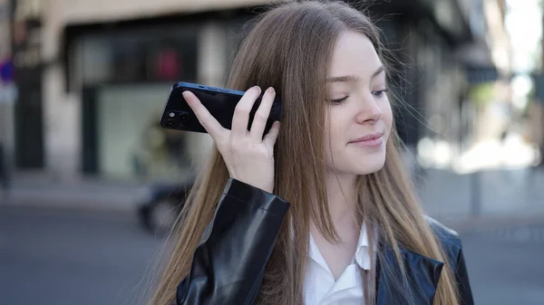 若いですブロンド女性笑顔自信に満ちたリスニング音声メッセージによってザスマートフォンによってストリート — ストック写真