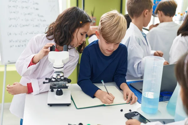 Schülergruppe Mit Mikroskopschrift Auf Notizbuch Labor Klassenzimmer — Stockfoto