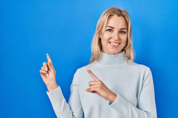 Young Caucasian Woman Standing Blue Background Smiling Looking Camera Pointing — Stockfoto