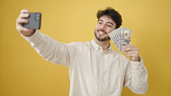 Genç Spanyol Adam Izole Edilmiş Sarı Arka Planda Dolarları Elinde — Stok fotoğraf