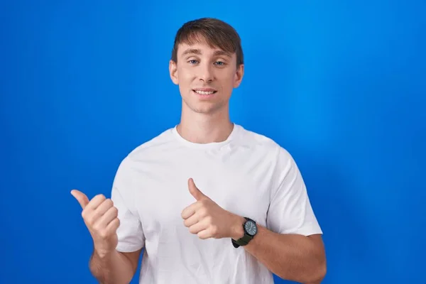Caucasian Blond Man Standing Blue Background Pointing Back Hand Thumbs — Stock Photo, Image
