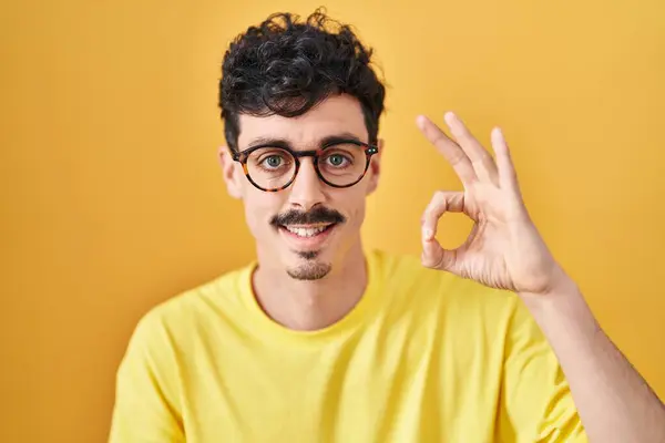 Hispanic Man Bär Glasögon Stående Över Gul Bakgrund Ler Positivt — Stockfoto