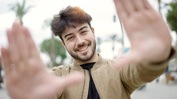 Joven Hispano Sonriendo Confiado Haciendo Gesto Marco Con Las Manos —  Fotos de Stock