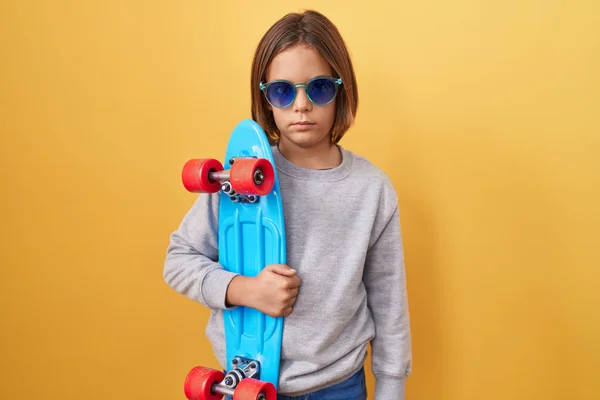 Kleiner Hispanischer Junge Mit Sonnenbrille Skateboarder Und Nüchternem Gesichtsausdruck Der — Stockfoto