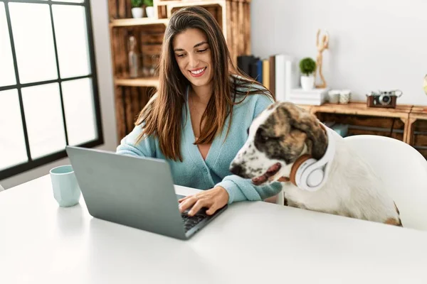 Jovem Mulher Usando Laptop Sentado Mesa Com Cão Usando Fones — Fotografia de Stock