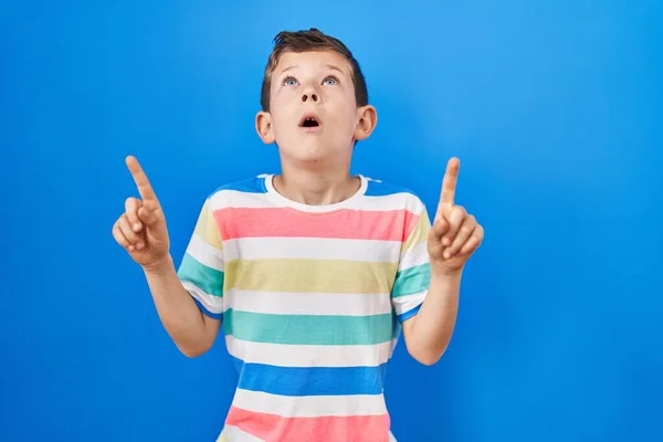 Jovem Caucasiano Criança Sobre Fundo Azul Espantado Surpreso Olhando Para — Fotografia de Stock