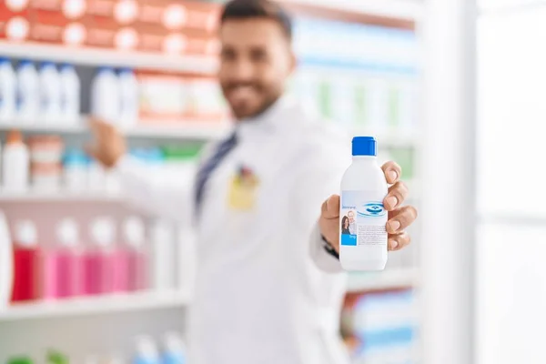 Young Hispanic Man Pharmacist Smiling Confident Holding Medication Bottle Pharmacy — Stockfoto