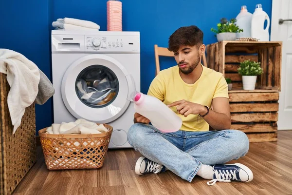 Young Arab Man Looking Detergent Bottle Sitting Floor Laundry Room — 图库照片
