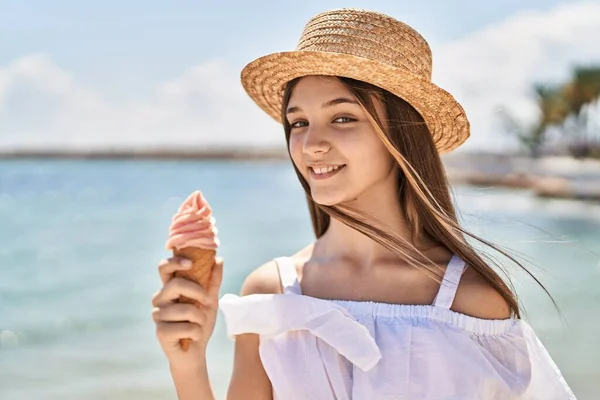 Adorable girl tourist smiling confident eating ice cream at seaside