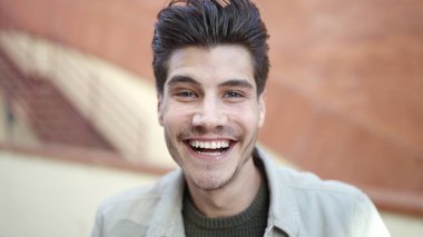 Sokakta kendinden emin gülümseyen İspanyol genç adam.