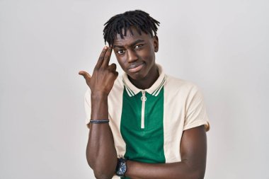 Rastalı Afrikalı bir adam izole edilmiş arka planda durup kendini ve parmaklarını silah gibi gösteren birini vuruyor, intihar jesti.. 