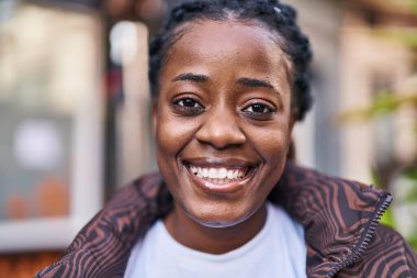 Sokakta kendine güvenen Afrikalı Amerikalı kadın gülümsüyor