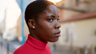 Sokakta ciddi bir ifadeyle duran Afrikalı Amerikalı kadın.