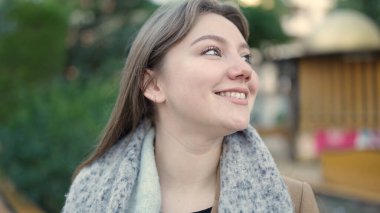 Young blonde woman smiling confident looking to the side at park